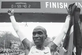  ?? Alex Halada / AFP via Getty Images ?? Kenya’s Eliud Kipchoge celebrates after busting the two-hour barrier for the marathon on Saturday in Vienna. As the race was unsanction­ed, it is not a record.