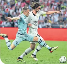  ??  ?? Aaron Ramsey challenges PSG’s Adrien Rabiot