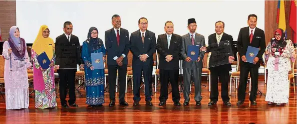  ??  ?? Dr Amin (sixth from left) posing for a group photo after presenting the certificat­es to the schools.