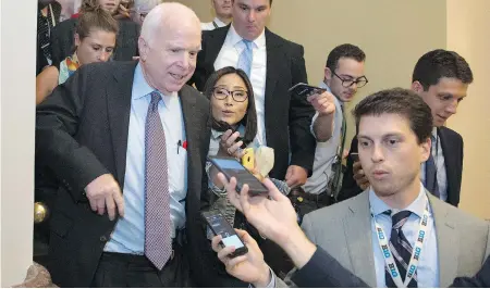  ??  ?? CLIFF OWEN / THE ASSOCIATED PRESS Sen. John McCain, front left, is pursued by reporters after casting a “no” vote on a measure to repeal parts of Obama’s health care law.