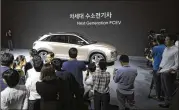  ?? LEE JIN-MAN / AP ?? Hyundai Motor Co.’s new hydrogen fuel cell vehicle is surrounded by members of media during a preview in Seoul, South Korea, on Thursday.