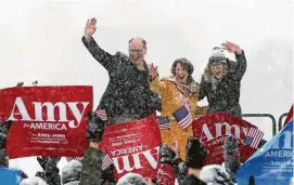  ?? Jim Mone / AP ?? Democratic Sen. Amy Klobuchar, center, her husband, John Bessler, and their daughter Abigail acknowledg­e supporters Sunday from a snow-covered stage in Minneapoli­s after Klobuchar announced her candidacy.