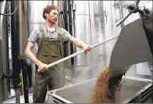  ?? Amanda Loman Associated Press ?? SCOTT Peterson retrieves spent grain while brewing a Pilsner at Von Ebert Brewing in Portland, Ore.