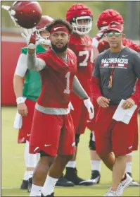  ?? NWA Democrat-Gazette/David Gottschalk ?? BACK TO WORK: Arkansas Razorback Jared Cornelius catches his helmet July 17 during practice on campus in Fayettevil­le. Cornelius, who was cut from the 105-man roster due to a back injury, can return to practice now that classes have started at the...