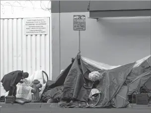  ?? JEFF CHIU/ASSOCIATED PRESS FILE PHOTO ?? A man stoops in November near tents set up on a sidewalk in San Francisco. When censustake­rs tried to count the nation’s homeless population, they ran into many problems that could threaten the accuracy of the effort.