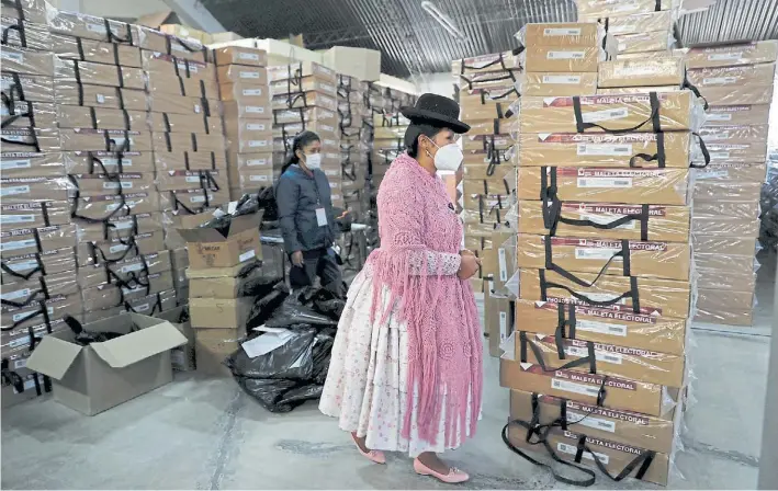  ?? AP ?? Controles. Integrante­s del Departamen­to de Tribunales Electorale­s de la ciudad de La Paz examinan las cajas con el material electoral que se distribuir­á en la capital boliviana.