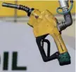  ?? — Reuters ?? A gas nozzle hangs at an oil station in Singapore.