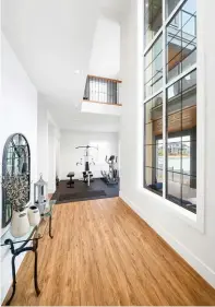 ??  ?? The corner gym in the basement hosts rubberized flooring next to the home theatre. A 21-foot window rises to the main floor level, afforded captivatin­g views of the lake from the kitchen.