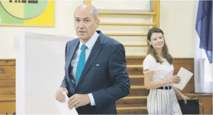  ?? Picture: AFP ?? MAKING HIS MARK. Janez Jansa, former Slovenian prime minister and president of the SDS party, and his wife Urska Bacovnik arrive to cast their ballots at a polling station.