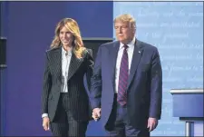  ?? JULIO CORTEZ, FILE - THE ASSOCIATED PRESS ?? President Donald Trump and first lady Melania Trump hold hands on stage after the first presidenti­al debate at Case Western University and Cleveland Clinic, in Cleveland, Ohio, Sept. 29.