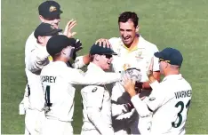  ?? ?? Australia players are delighted after picking up an England wicket