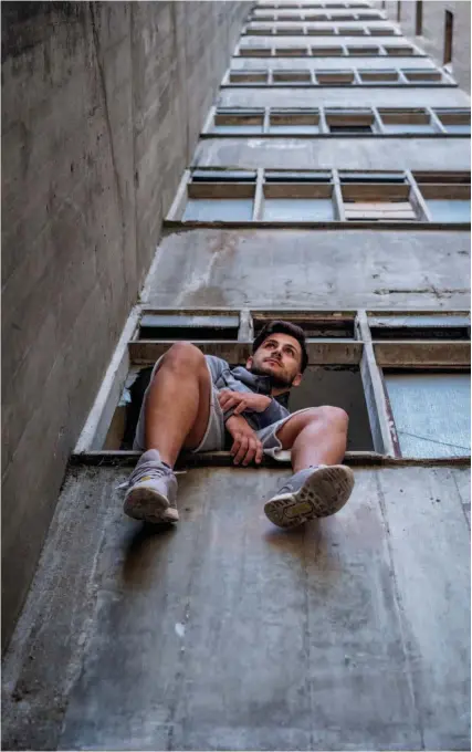  ??  ?? M Julinho Silva fotografad­o numa janela da Torre 1, o prédio onde mora desde que nasceu há 26 anos