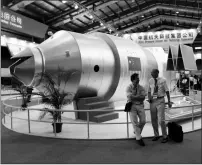  ?? ASSOCIATED PRESS ?? IN THIS NOV. 16, 2010, FILE PHOTO, visitors sit beside a model of China’s Tiangong-1 space station at the 8th China Internatio­nal Aviation and Aerospace Exhibition in Zhuhai in southern China’s Guangdong Province. The defunct space station re-entered...