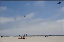  ?? (File Photo/AP/ Lenny Ignelzi) ?? Part of a Navy helicopter squadron flies over beachgoers May 22, 2012, on the Coronado Beach in California.