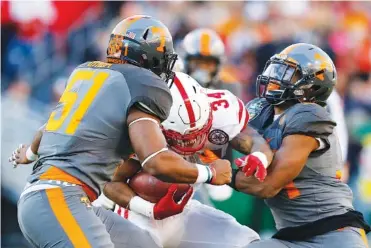  ?? STAFF FILE PHOTO BY DOUG STRICKLAND ?? Tennessee linebacker­s Kenny Bynum, left, and Darrin Kirkland Jr., tackle Nebraska’s Terrell Newby during the Music City Bowl last December. Bynum has graduated, but Kirkland is back and expected to be a leader of the defense this season.