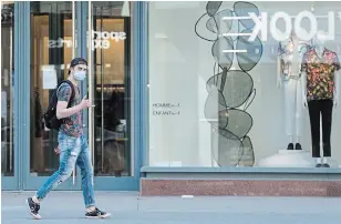  ?? GRAHAM HUGHES THE CANADIAN PRESS FILE PHOTO ?? A man wearing a face mask walks on Sainte-Catherine street in Montreal. Authoritie­s have been sending mixed messages about masks, but now are encouragin­g people to wear them in public.