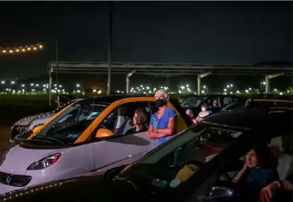  ?? Alexandra Wimley/ Post- Gazette ?? People watch from their cars as musicians from the Pittsburgh Symphony Orchestra perform Sunday at the City Theatre’s Drive- In Arts Festival at Hazelwood Green.