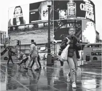  ?? HENRY NICHOLLS • REUTERS ?? People walk through Picadilly Circus in London on Monday.