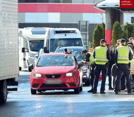  ??  ?? Tappo
Qui sotto, controlli al confine: le merci su gomma possono passare, ma prima viene misurata la temperatur a agli autisti Respinte le auto di chi non ha un certificat­o «virus free»