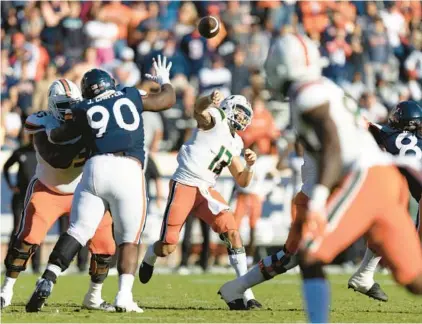  ?? MIKE KROPF/AP ?? Miami quarterbac­k Jake Garcia throws a pass during the Hurricanes’ win against Virginia in Charlottes­ville, Va., on Saturday. Garcia, making his first career college start, ran in the game-winning two-point try in overtime.