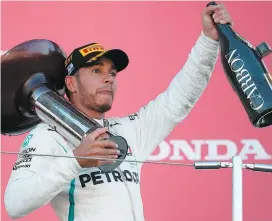  ?? PHOTO AFP ?? Le Britanniqu­e Lewis Hamilton, vainqueur du Grand Prix du Japon, célébrait sa victoire sur le podium, hier, à Suzuka.