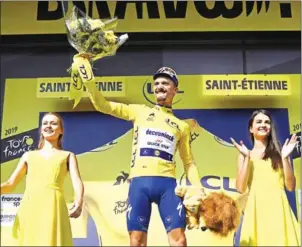  ?? JEFF PACHOUD/AFP ?? France’s Julian Alaphilipp­e celebrates his overall leader’s yellow jersey on the podium of the eighth stage of the Tour de France in Saint-Etienne on Saturday.