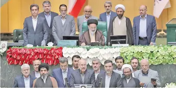  ?? — AFP photo ?? Ghalibaf (bottom centre) stands among members of the parliament after being elected as parliament speaker at the Iranian parliament in Tehran.