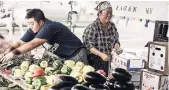  ?? AP ?? Mao Lee (left) and her mother Ma Lee sell produce grown on the family farm in Eagan, Minnesota, called Lee Farms, at the Maple Grove Farmers’ Market on August 17.