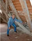  ??  ?? Kirchenpfl­eger Gerhard Zöh zeigt faules Holz im Dachstuhl, das ersetzt wurde.