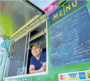  ?? JEFF McINTOSH/CANADIAN PRESS ?? Emmanuel Guardado, who owns the QueChivo Salvadoran food truck in Calgary,always dreamed of starting his own food business, but it was only when he lost his job in the oil and gas industry that he decided to dive in.