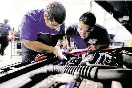  ?? Gary Coronado / Houston Chronicle ?? Students Sotero Neri, left, and Jose Martinez check for leaks in a car’s air-conditioni­ng system at Universal Technical Institute.