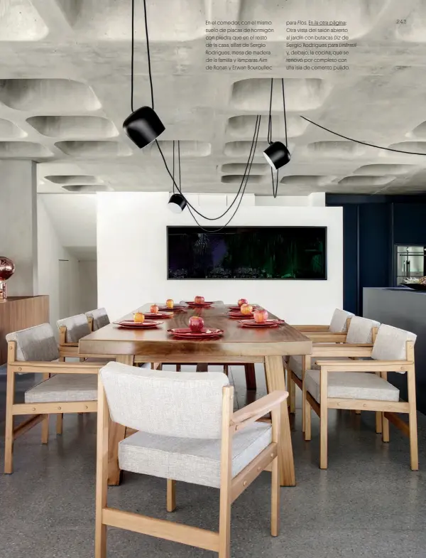  ??  ?? En el comedor, con el mismo suelo de placas de hormigón con piedra que en el resto de la casa, sillas de Sergio Rodrigues, mesa de madera de la familia y lámparas Aim de Ronan y Erwan Bouroullec para Flos. En la otra página: Otra vista del salón abierto al jardín con butacas Diz de Sergio Rodrigues para LinBrasil y, debajo, la cocina, que se renovó por completo con una isla de cemento pulido.