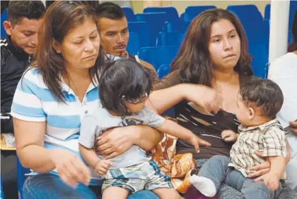  ?? Leila Macor, AFP ?? Mothers and children wait to be assisted by volunteers in a humanitari­an center last month in McAllen, Texas.