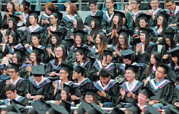  ?? DING TING / XINHUA ?? Students at Fudan University in Shanghai celebrate their graduation in 2017.