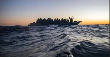  ?? (AP/Bruno Thevenin) ?? Migrants and refugees from African nations wait for assistance in February aboard a crowded wooden boat in the Mediterran­ean as aid workers of the Spanish NGO Open Arms approach.