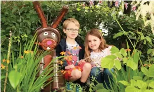  ??  ?? ● Albie and Etty Pearson exploring the sculptures at the Wall of History Gardens maintained by Bacup Pride in 2019 when the last Bacup Flowerpot Festival was held