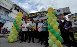  ?? ?? Dr Abdul Rahman (second le ), Hilmy (le ) and Satok assemblyma­n Datuk Ibrahim Baki (second right) cut the ribbon to officiate the opening of the Satok Ramadan Bazaar.