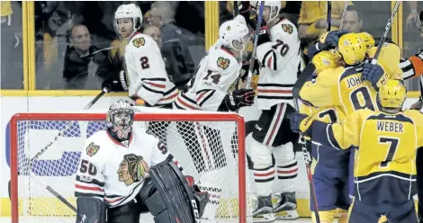  ?? MARK HUMPHREY/AP FILES ?? Chicago goalie Corey Crawford looks up at the scoreboard as Nashville players celebrate a goal during the first round of the NHL playoffs. The Blackhawks are a consistent regular-season powerhouse, but have been eliminated in the first round of the...