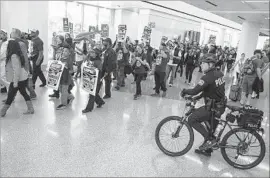  ?? Brian van der Brug Los Angeles Times ?? LABOR EXPERTS say a hike in the minimum wage has proved to be a popular issue with voters of all political parties. Above, protesters at LAX on Tuesday.