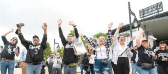  ?? TYLER LARIVIERE/SUN-TIMES PHOTOS ?? White Sox fans cheer as Sox staff throw T-shirts at them during the Change the Game Rally in the parking lot at Guaranteed Rate Field on Monday.