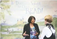  ?? STAFF PHOTO BY ERIN O. SMITH ?? Candy Carson speaks Monday with Gale Hinton, the artist who painted the Ben Carson Reading Room at Lookout Valley Elementary School. Hinton, of Knoxville, has painted a variety of canvases including corporate offices, hospitals and about 300 schools...