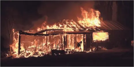  ?? JOSH EDELSON, AFP/GETTY IMAGES ?? A house is engulfed in flames from the Valley Fire in Seigler Springs, Calif., Sunday. The governor declared a state of emergency.