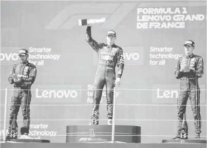  ?? — Gambar AFP ?? JUARA: Verstappen (tengah) memegang trofi sambil diapit oleh Hamilton (kiri), dan Russell di atas podium sebaik tamat perlumbaan Formula Satu Grand Prix Perancis di litar Paul-Ricard di Le Castellet, kelmarin.