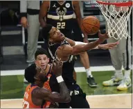  ??  ?? Bucks forward Giannis Antetokoun­mpo (34) goes to the basket over Phoenix Suns center Deandre Ayton (22) and guard Devin Booker during the second half of Game 6in Milwaukee on Tuesday.