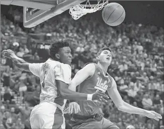  ?? John Locher
Associated Press ?? ARIZONA FRESHMAN Stanley Johnson, left, has just blocked a shot by UCLA’s Gyorgy Goloman during the first half at Las Vegas. Goloman didn’t score in 15 minutes off the bench.