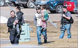  ?? [T’XER ZHON KHA /THE POST-CRESCENT] ?? Police officers escort a family to safety from an apartment complex in Rothschild, Wisconsin, after the shooting there Wednesday afternoon.