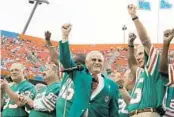  ?? LYNNE SLADKY/AP ?? Shula, center, waves with former players from the unbeaten 1972 team during a ceremony at Hard Rock Stadium on Dec. 16, 2007.