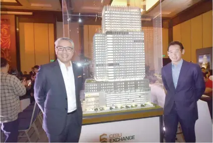  ?? SUNSTAR FOTO / ALLAN CUIZON ?? VALUE PROPOSITIO­N. Arthaland executive vice presidents Christophe­r Narciso (left) and Leo Po stand next to a scale model of Cebu Exchange, a LEED-certified building built for clients who value saving energy, conserving water and recycling waste.