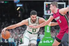  ?? STEVEN SENNE/AP PHOTO ?? Boston Celtics forward Jayson Tatum (0) drives past Miami Heat forward Nikola Jovic (5) on Sunday in the first half of Game 1 of an NBA first-round playoff series in Boston.