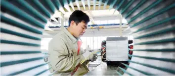  ?? — Reuters ?? A man works on an electric machine parts at a workshop of an equipment manufactur­ing company in Weifang, Shandong province, China.